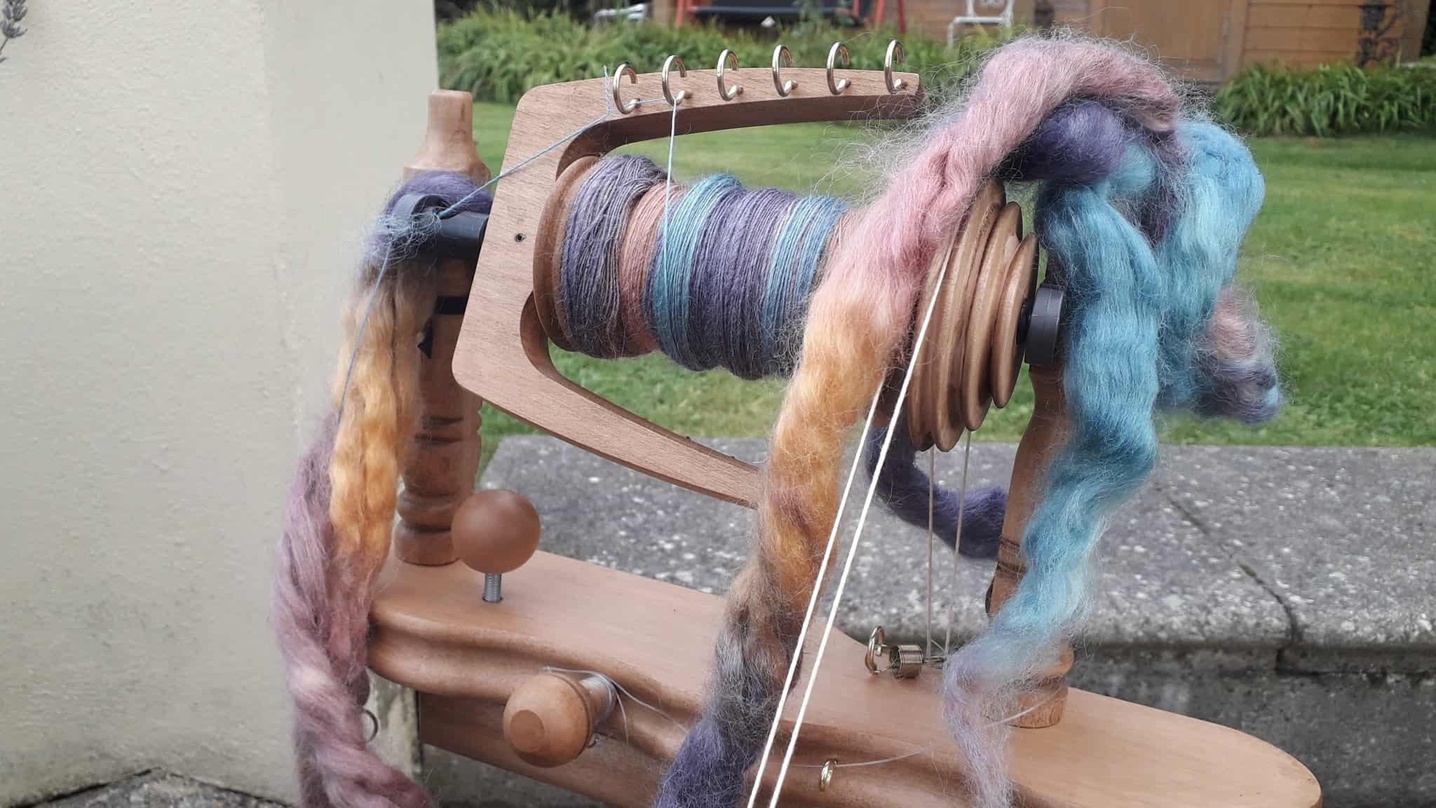 Spinning wheel with colourful yarn fibre.