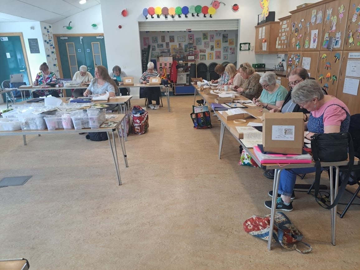 Participants showcasing patchwork quilts after a craft workshop